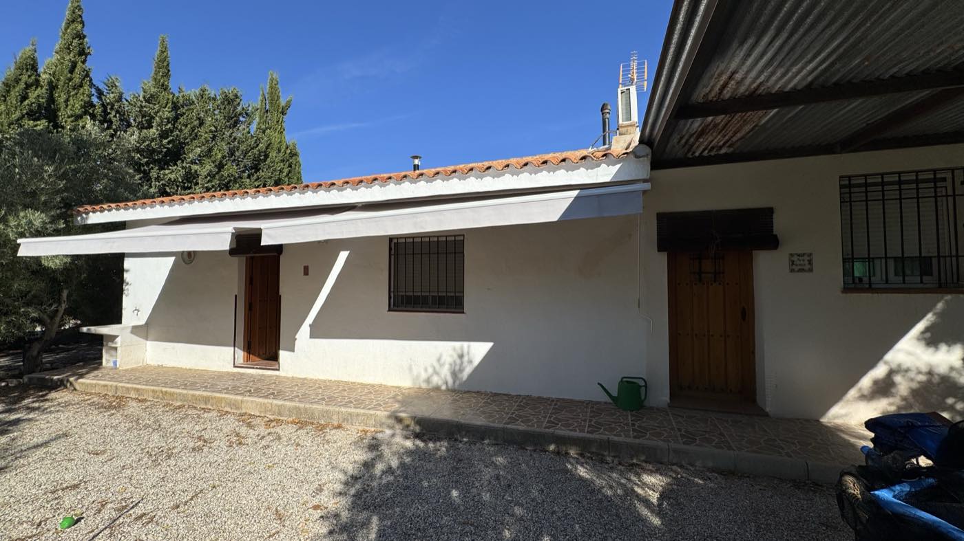 Fachada de la casa, de una planta, con toldo sobre la entrada