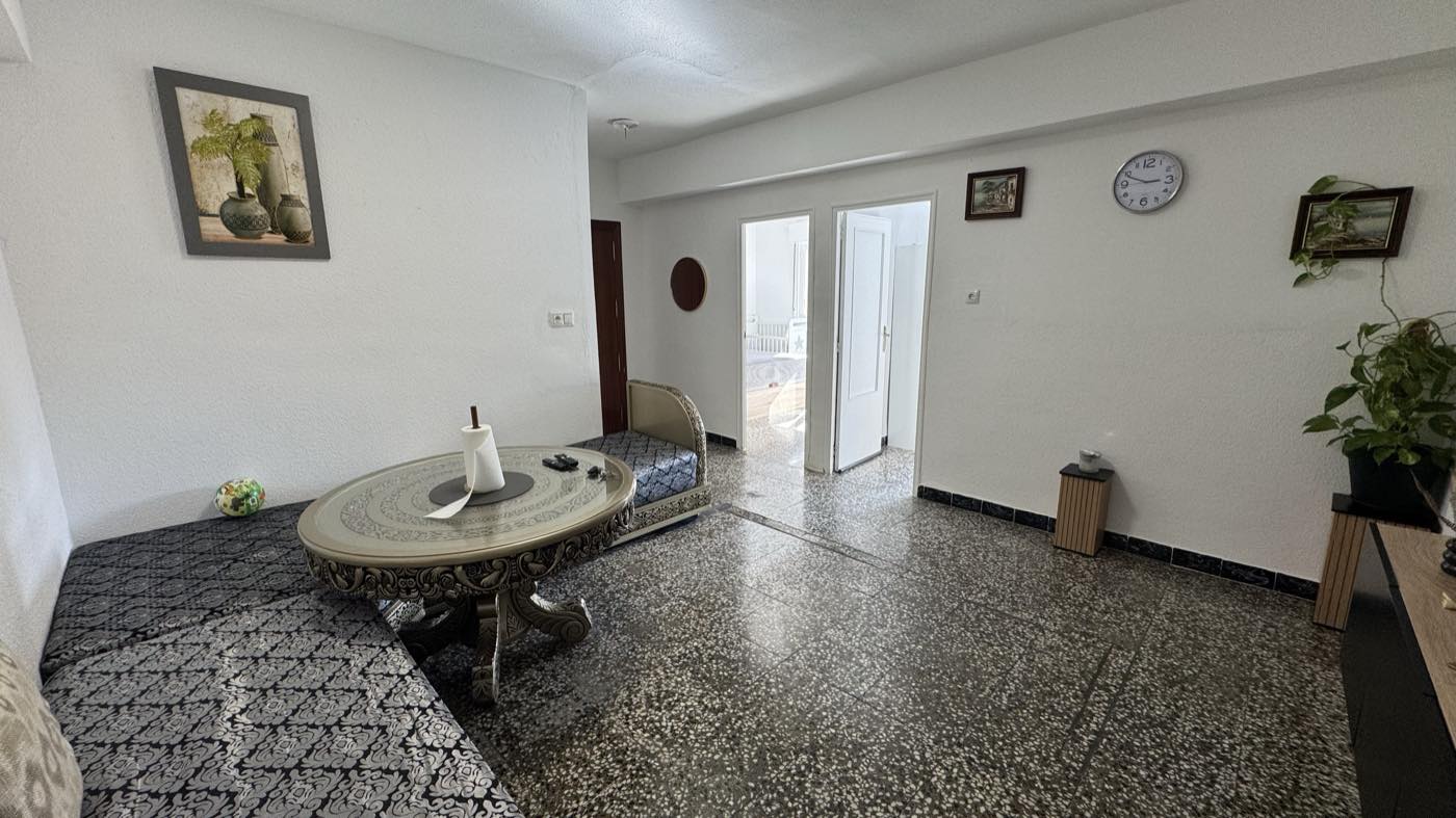 Salón del piso, con suelo de terrazo y paso a las habitaciones